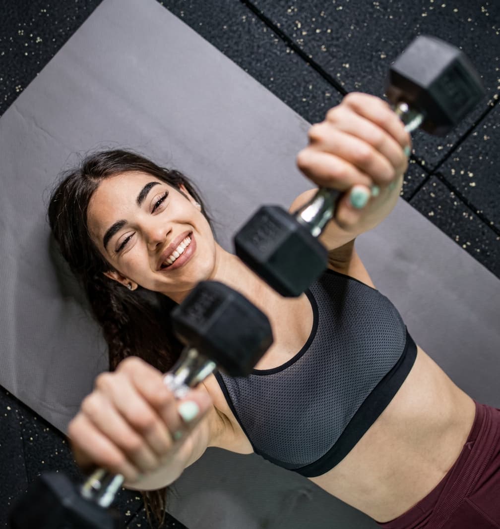 A client lifting dumbbells during a focused strength training session.